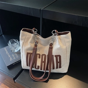 Off-white canvas tote bag with brown letter print and leather chain handles for daily use