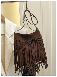 Close-up of brown suede shoulder bag featuring long fringe tassels in bohemian style