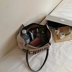Off-white canvas tote bag with brown leather trim and CH logo shown from a 45-degree angle