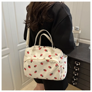 Detailed view of white corduroy tote bag with cute red strawberry print and multi-pocket design