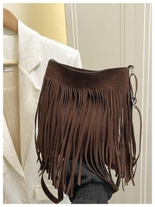 Detail of bohemian dark brown suede crossbody bag with long tassel fringe decoration