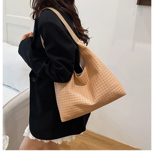 Woven texture Hobo tote bag in beige shown on shoulder for a retro daily commute style