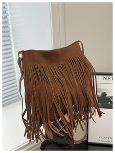Detail of the brown bohemian tassel crossbody bag with soft faux suede fringe texture