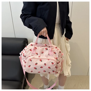 Borsa a tracolla in velluto rosa con stampa fragola e tracolla su una modella