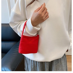 Close-up of bright red nylon bucket bag with 3D letter embroidery and thin top handle
