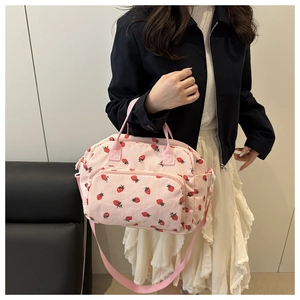 Detail of pink corduroy lunch bag with red strawberry pattern and adjustable strap