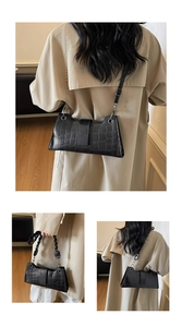 Detail of black crocodile texture baguette bag featuring versatile strap and sleek PU leather