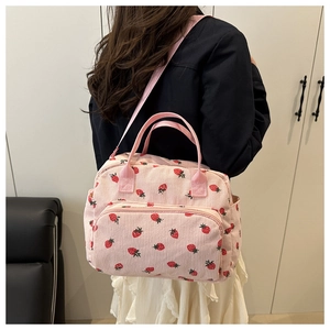 Detailed view of pink corduroy lunch tote featuring strawberry print and side pockets