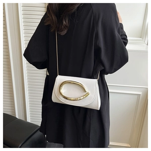 Detailed view of white leather shoulder bag with gold C-buckle and elegant chain strap