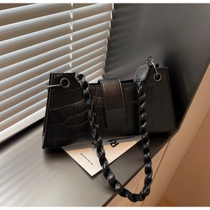 Close-up of black crocodile pattern faux leather with woven chain strap detail