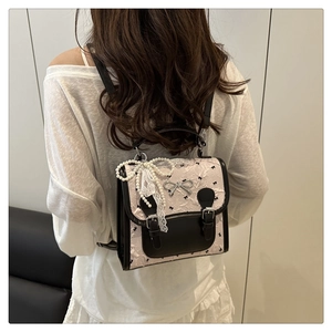Vue arrière d'un mini sac à dos en jacquard rose avec bordures en cuir noir et nœud