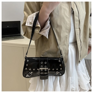 Détail du sac punk en cuir verni noir avec des rivets argentés et des boucles décoratives