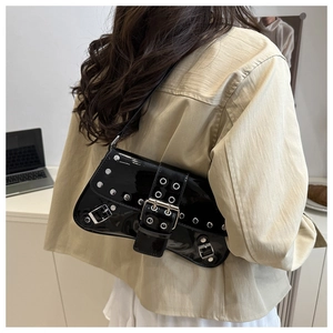 Side view of punk style black patent leather shoulder bag with silver studs and buckles