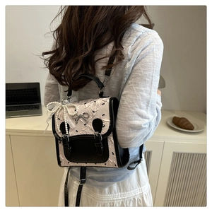 Mini sac à dos rose texturé avec logo nœud en métal et pendentif en dentelle de perles
