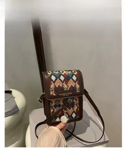 Detail of coffee brown crossbody bag featuring geometric woven pattern and leather flap