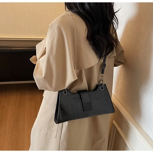 Detail of black crocodile texture baguette bag with silver ring buckle and PU strap