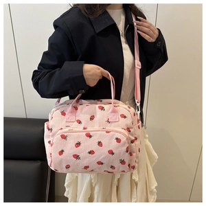 Dettaglio della borsa in velluto a coste rosa con stampa fragola e tracolla