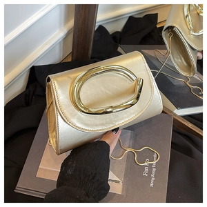 Détail du sac à chaîne doré champagne avec poignée métallique distinctive en forme de C