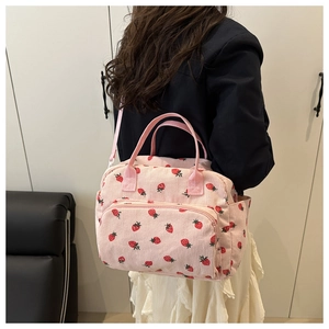 Detail of pink corduroy crossbody bag with strawberry print and detachable strap