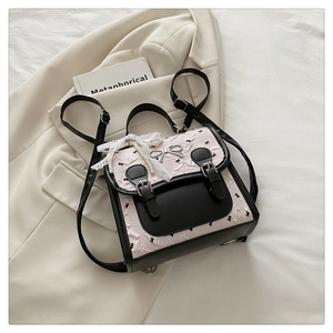 Détail d'un sac à dos patchwork noir et blanc avec dentelle, perles et broderies fines