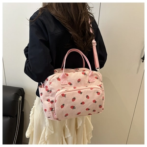 Rear view of a model wearing the pink strawberry corduroy shoulder bag with strap
