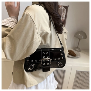 Vue latérale d'un sac à bandoulière punk noir avec rivets argentés porté par un mannequin