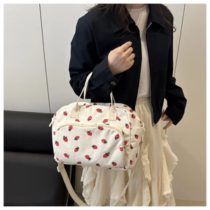 Detail of strawberry corduroy crossbody bag with adjustable strap and front zipper pocket
