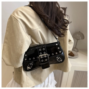Détail du sac à bandoulière en cuir verni noir avec œillets argentés et boucles Y2K