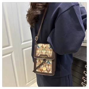 Detail of the vintage crossbody phone bag with jacquard pattern and leather trim