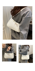 Detail of white litchi pattern underarm bag with gold metal bow and zipper closure