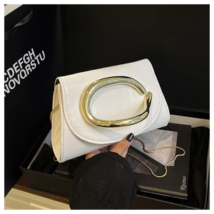 Détail du sac blanc avec boucle dorée en forme de C et bandoulière en chaîne métallique fine