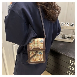 Detailed back view of a model wearing a geometric patterned crossbody phone bag in brown