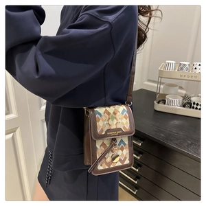 Detail of vintage crossbody bag showing geometric pattern and gold logo lettering