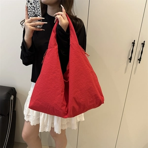 Detailed view of red large capacity tote bag with drawstring and triangle folding
