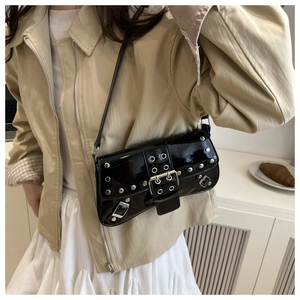 Detailed view of black patent leather underarm bag with silver studs and Y2K punk style
