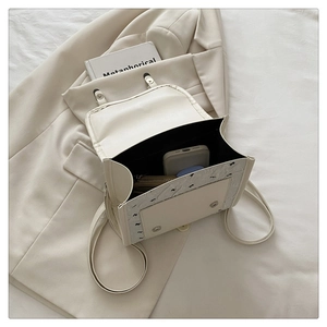 Vue détaillée de la capacité intérieure du sac à dos en cuir blanc cassé à nœud noir