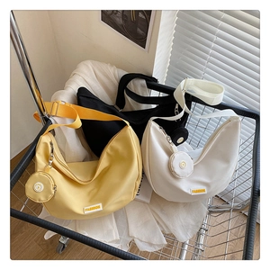 Detailed set of three half-moon nylon bags in yellow, black, and white with coin pouches