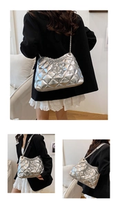 Detail of silver metallic quilted shoulder bag with chain strap and pleated opening