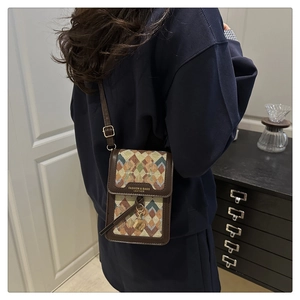 Close-up of retro crossbody bag with geometric patchwork and adjustable shoulder strap