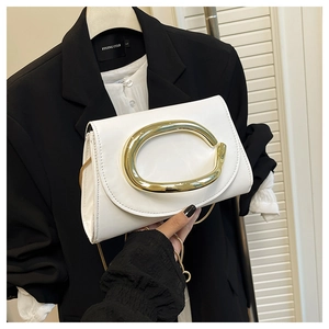 Détail de la sacoche en cuir blanc avec une boucle métallique dorée en forme de C