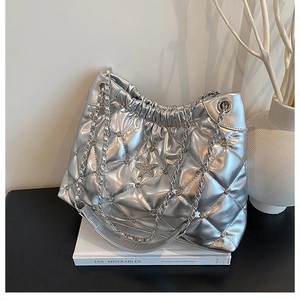 Detail of silver metallic tote bag with quilted pattern, rhinestone star, and chain strap