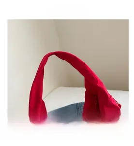 Close-up of wide shoulder strap and matte red nylon fabric on a large tote bag