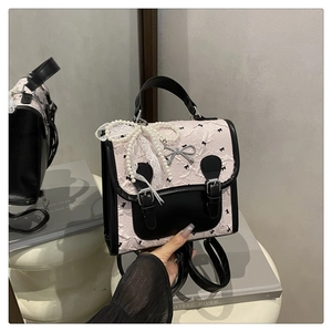 Détail du mini sac à dos rose à imprimé nœud avec boucle en métal et perle