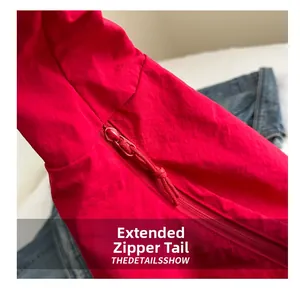 Close-up of red tote bag fabric texture featuring an extended zipper puller detail