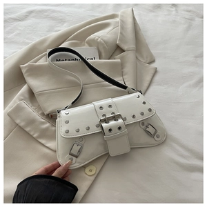 Detail of white glossy rivet underarm bag with silver studs on light suit jacket