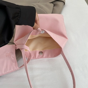 Pink nylon tote bag with magnetic closure and inner yellow lining for casual use