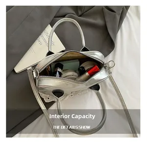 Detail view of silver Boston bag interior with lipstick and makeup essentials