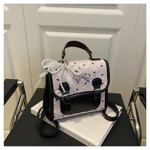 Détail du sac à dos en jacquard rose avec imprimé nœuds et breloque en perles
