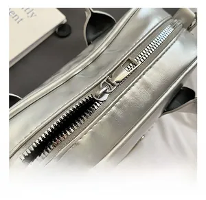 Detail of high-quality silver metal zipper on shiny silver leather Boston handbag