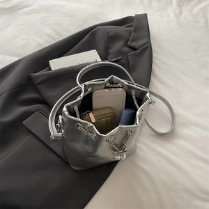 Silver metallic bucket bag with chain and pearl detail, shown with storage capacity